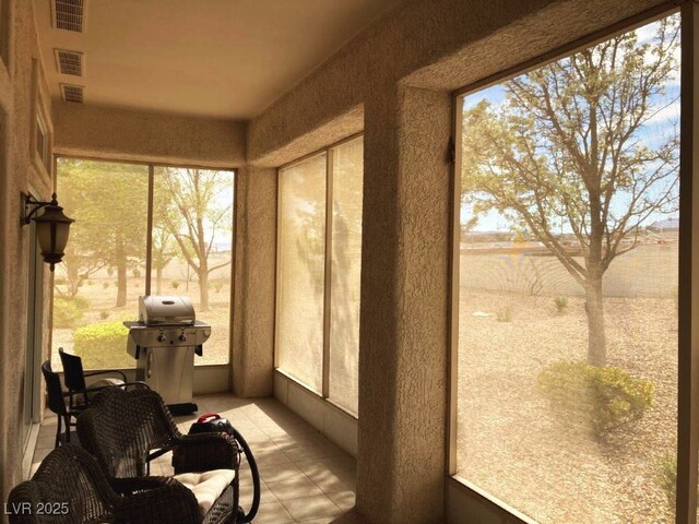 sunroom / solarium featuring plenty of natural light, visible vents, and tile patterned flooring