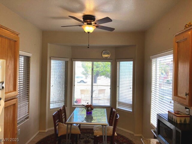 dining space featuring baseboards and a ceiling fan