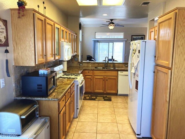 kitchen featuring tasteful backsplash, a sink, brown cabinetry, white appliances, and visible vents