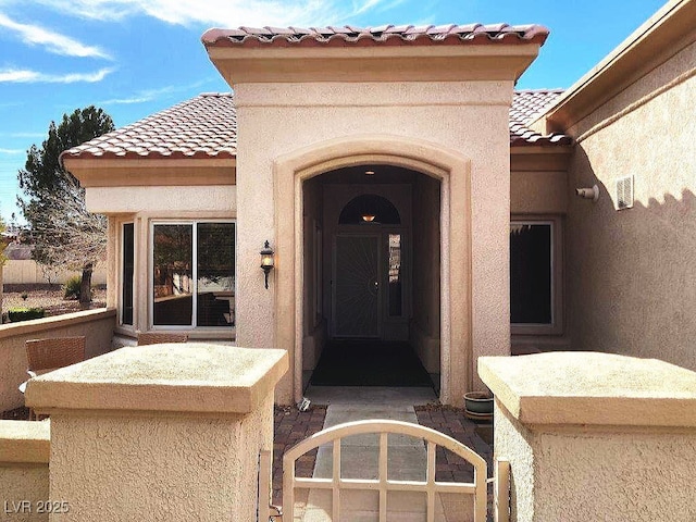 property entrance with stucco siding and a tiled roof