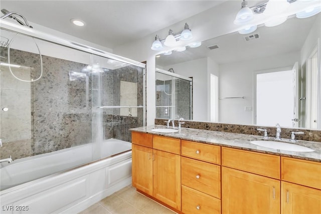 full bath with tile patterned flooring, shower / bath combination with glass door, and double vanity