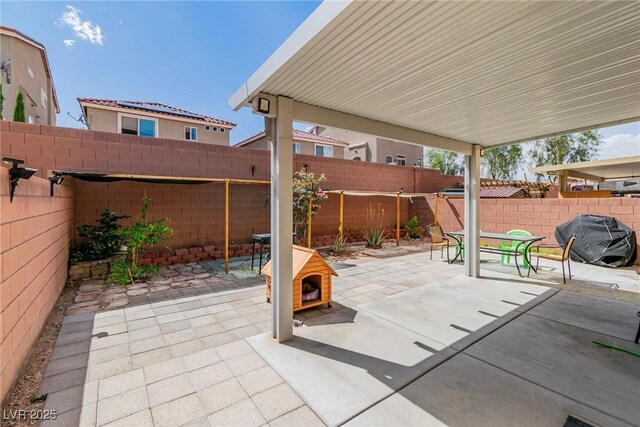 view of patio with area for grilling and a fenced backyard
