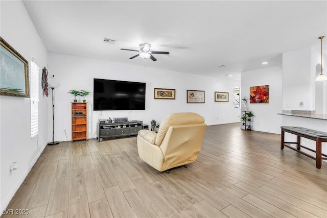 living area featuring a ceiling fan, light wood finished floors, plenty of natural light, and recessed lighting