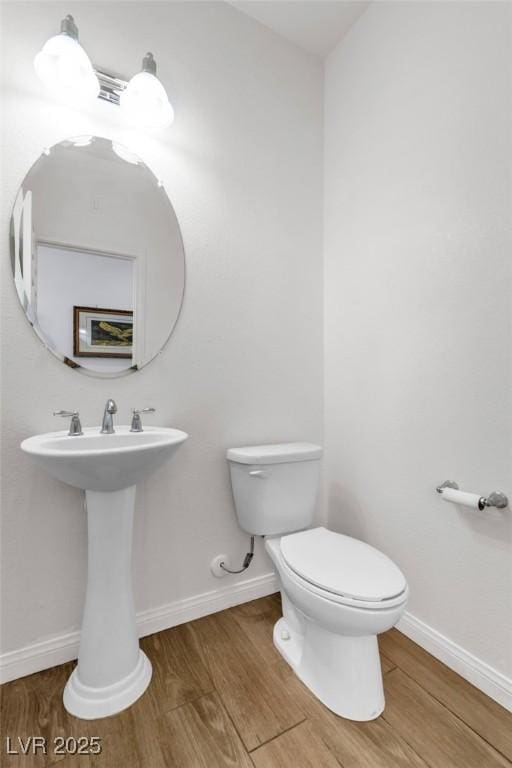 bathroom featuring wood finished floors, toilet, and baseboards