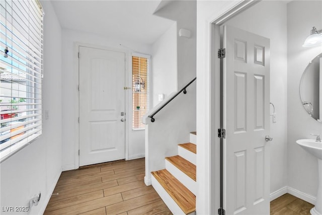 foyer featuring light wood-style floors, stairway, and baseboards