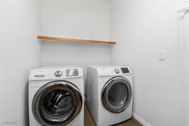 washroom with separate washer and dryer, wood finished floors, and baseboards