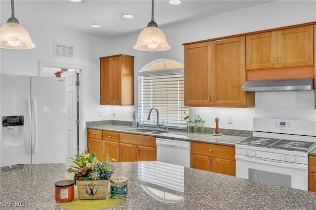 kitchen featuring white appliances, range hood, a sink, dark stone counters, and decorative light fixtures