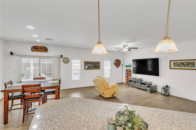 living room featuring healthy amount of natural light, wood finished floors, a ceiling fan, and recessed lighting