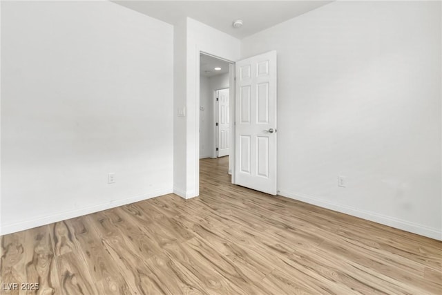 spare room featuring light wood-type flooring and baseboards
