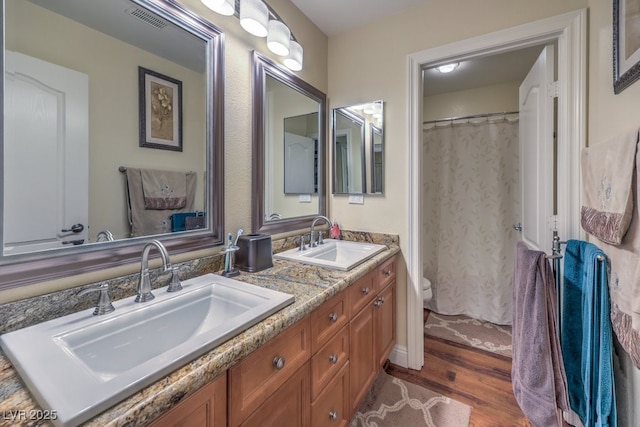 8429 Brackenfield Ave, Las Vegas, NV 89178 - bathroom featuring double vanity, wood finished floors, toilet, and a shower with curtain