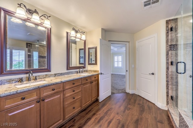 8429 Brackenfield Ave, Las Vegas, NV 89178 - bathroom featuring a shower stall, wood finished floors, double vanity, and baseboards