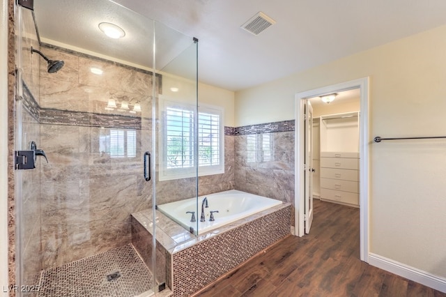 8429 Brackenfield Ave, Las Vegas, NV 89178 - full bath featuring wood finished floors, a bath, a stall shower, a walk in closet, and baseboards