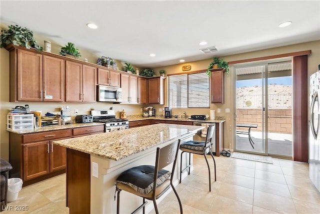 2612 Tullamore Creek Ln, Laughlin, NV 89029 - kitchen featuring appliances with stainless steel finishes, a kitchen bar, light stone counters, a center island, and recessed lighting