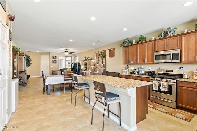 2612 Tullamore Creek Ln, Laughlin, NV 89029 - kitchen with stainless steel appliances, recessed lighting, brown cabinets, a center island, and a kitchen breakfast bar