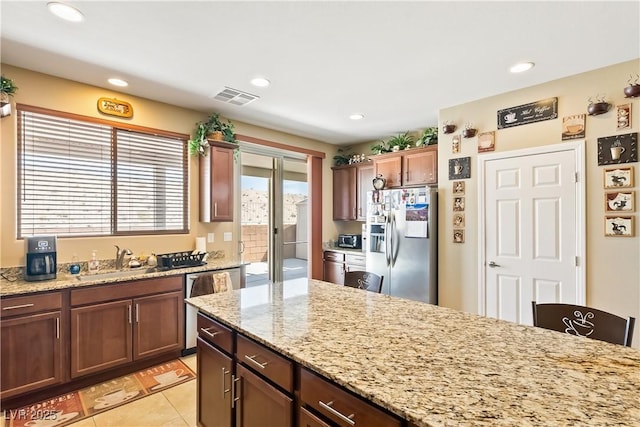 2612 Tullamore Creek Ln, Laughlin, NV 89029 - kitchen with appliances with stainless steel finishes, a sink, recessed lighting, light stone counters, and light tile patterned floors