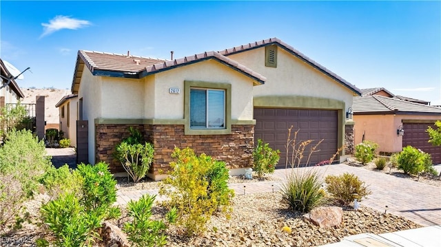 2612 Tullamore Creek Ln, Laughlin, NV 89029 - view of front facade with stucco siding, a garage, driveway, and stone siding
