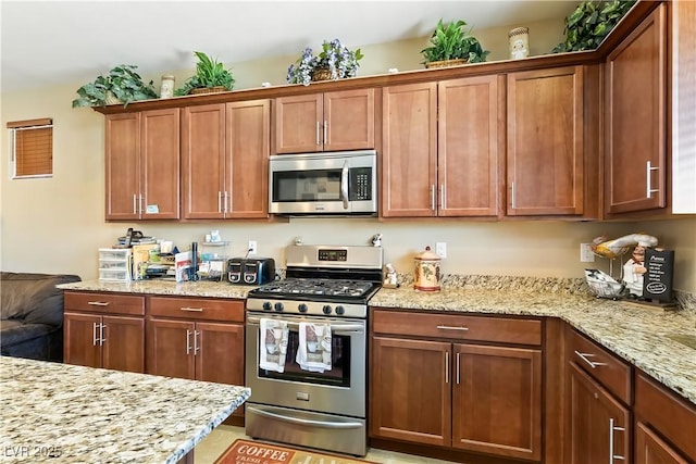 2612 Tullamore Creek Ln, Laughlin, NV 89029 - kitchen with appliances with stainless steel finishes, light stone counters, and brown cabinetry