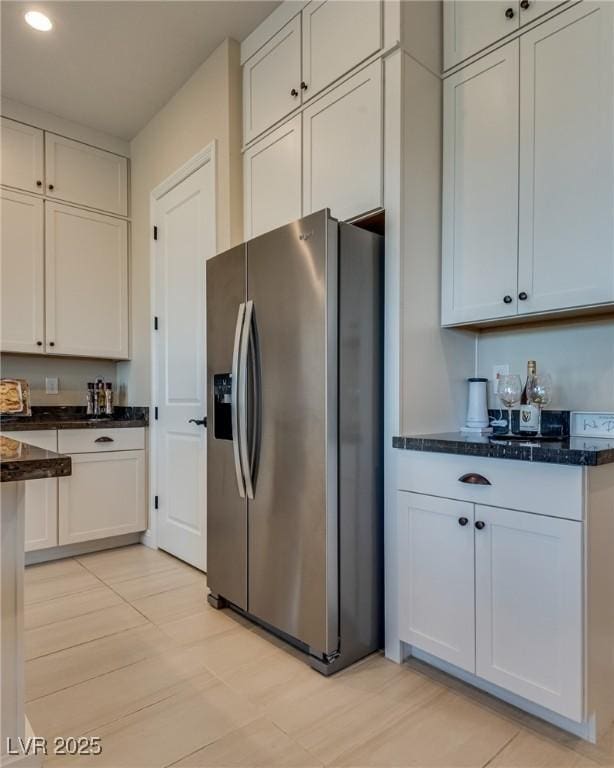 8944 Skye Canyon Ranch St, Las Vegas, NV 89166 - kitchen with stainless steel fridge with ice dispenser, recessed lighting, dark stone countertops, and white cabinetry