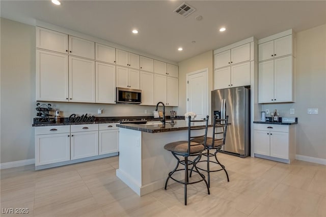 8944 Skye Canyon Ranch St, Las Vegas, NV 89166 - kitchen featuring appliances with stainless steel finishes, baseboards, a breakfast bar area, a kitchen island with sink, and recessed lighting