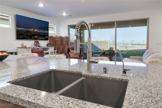 10216 Chrysolite Pl, Las Vegas, NV 89143 - kitchen with light stone counters, a sink, open floor plan, and recessed lighting