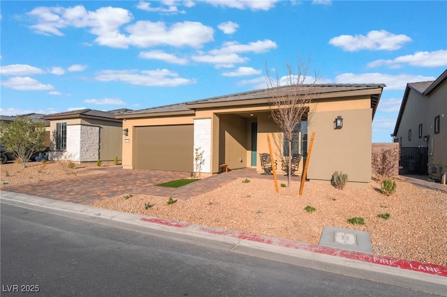 10216 Chrysolite Pl, Las Vegas, NV 89143 - view of front facade with stucco siding, decorative driveway, an attached garage, and solar panels