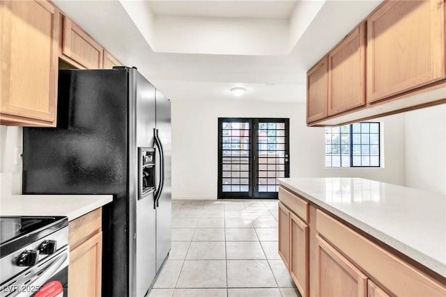 kitchen with black fridge with ice dispenser, light countertops, a raised ceiling, french doors, and light tile patterned floors