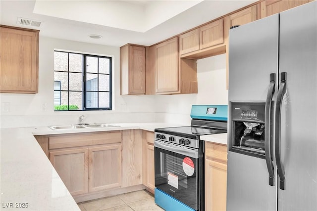 kitchen with light countertops, light tile patterned flooring, visible vents, light brown cabinets, and appliances with stainless steel finishes