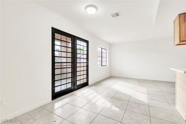 spare room with baseboards, visible vents, french doors, and light tile patterned floors