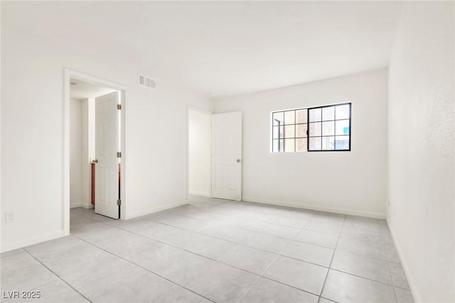 spare room with light tile patterned flooring, baseboards, and visible vents