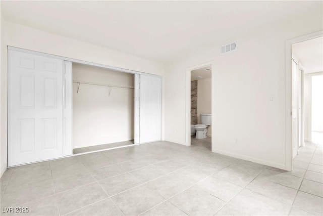 unfurnished bedroom featuring light tile patterned floors, baseboards, connected bathroom, visible vents, and a closet