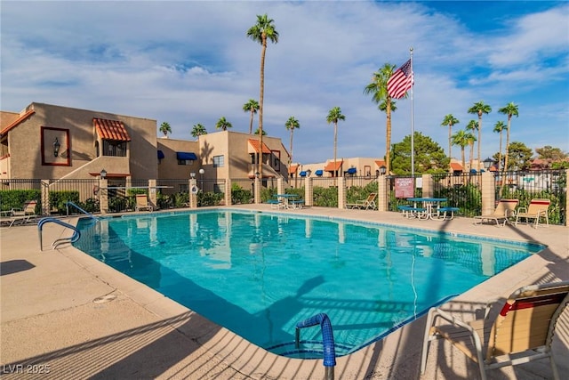 community pool with fence, a residential view, and a patio area