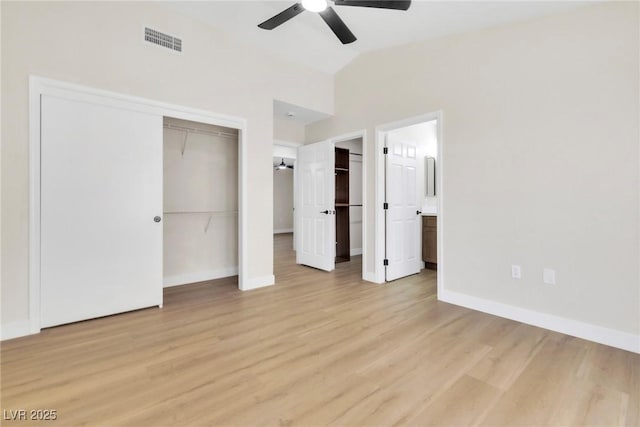 unfurnished bedroom featuring lofted ceiling, light wood-type flooring, baseboards, visible vents, and ensuite bathroom