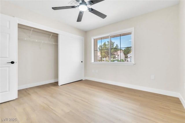 unfurnished bedroom with baseboards, a closet, light wood-style floors, and a ceiling fan