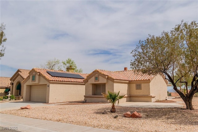 mediterranean / spanish house with stucco siding, a tile roof, a garage, and driveway