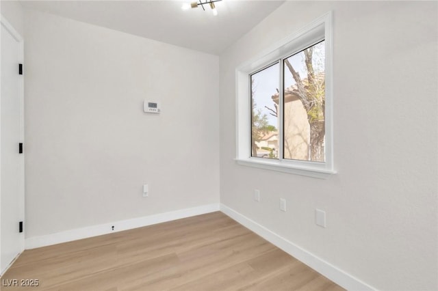 unfurnished room featuring baseboards and light wood finished floors