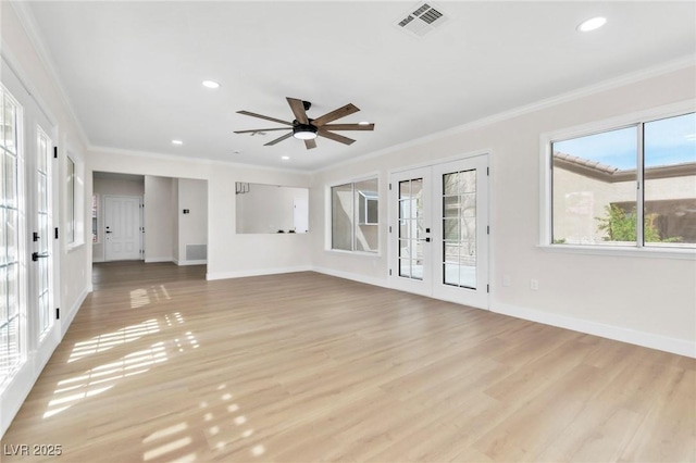 unfurnished living room featuring french doors, crown molding, light wood-style floors, and baseboards