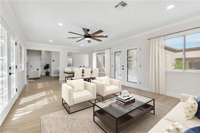 living area featuring french doors, light wood-style flooring, ornamental molding, and baseboards