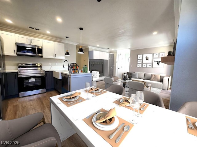 4050 Pacific Harbors Dr Unit 209, Las Vegas, NV 89121 - kitchen featuring visible vents, a peninsula, appliances with stainless steel finishes, a sink, and open floor plan