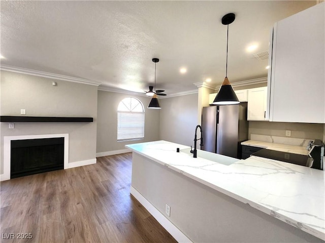 4050 Pacific Harbors Dr Unit 209, Las Vegas, NV 89121 - kitchen with a peninsula, light stone countertops, wood finished floors, ceiling fan, and freestanding refrigerator
