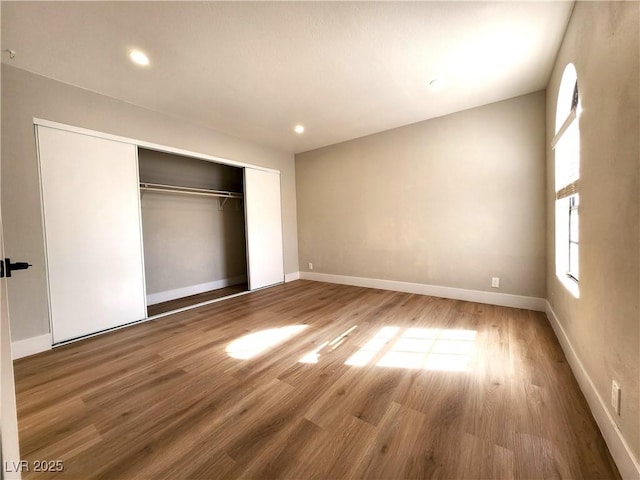 4050 Pacific Harbors Dr Unit 209, Las Vegas, NV 89121 - unfurnished bedroom featuring a closet, baseboards, and wood finished floors