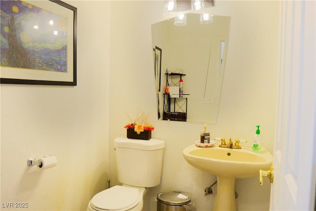 half bathroom featuring toilet and a sink
