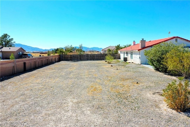 view of yard featuring a mountain view and fence
