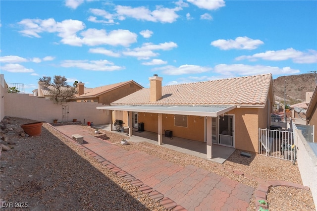 1010 Armillaria St, Henderson, NV 89011 - rear view of house with a tile roof, a patio area, a chimney, stucco siding, and a fenced backyard