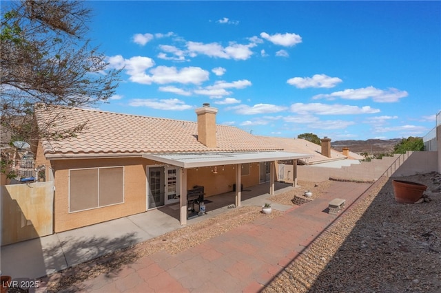 1010 Armillaria St, Henderson, NV 89011 - back of house with a tile roof, a patio area, a chimney, stucco siding, and a fenced backyard