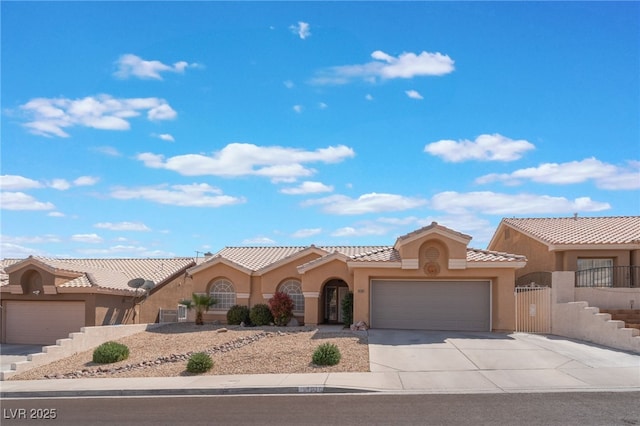 1010 Armillaria St, Henderson, NV 89011 - mediterranean / spanish-style house featuring a tile roof, a gate, driveway, stucco siding, and an attached garage