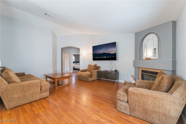 1010 Armillaria St, Henderson, NV 89011 - living room with arched walkways, a glass covered fireplace, light wood finished floors, and visible vents