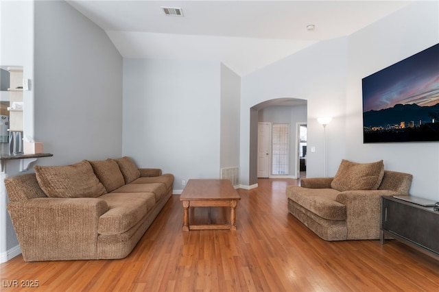 1010 Armillaria St, Henderson, NV 89011 - living area with light wood-style flooring, arched walkways, vaulted ceiling, and visible vents