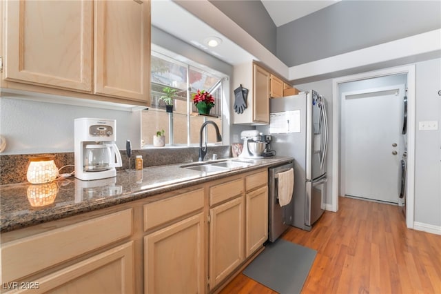 1010 Armillaria St, Henderson, NV 89011 - kitchen with light wood-type flooring, dark stone counters, a sink, light brown cabinets, and appliances with stainless steel finishes