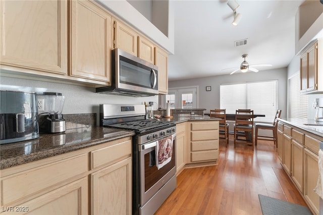 1010 Armillaria St, Henderson, NV 89011 - kitchen with light wood-type flooring, light brown cabinetry, ceiling fan, visible vents, and appliances with stainless steel finishes