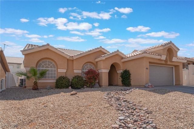 1010 Armillaria St, Henderson, NV 89011 - mediterranean / spanish-style home with stucco siding, a tile roof, an attached garage, and driveway